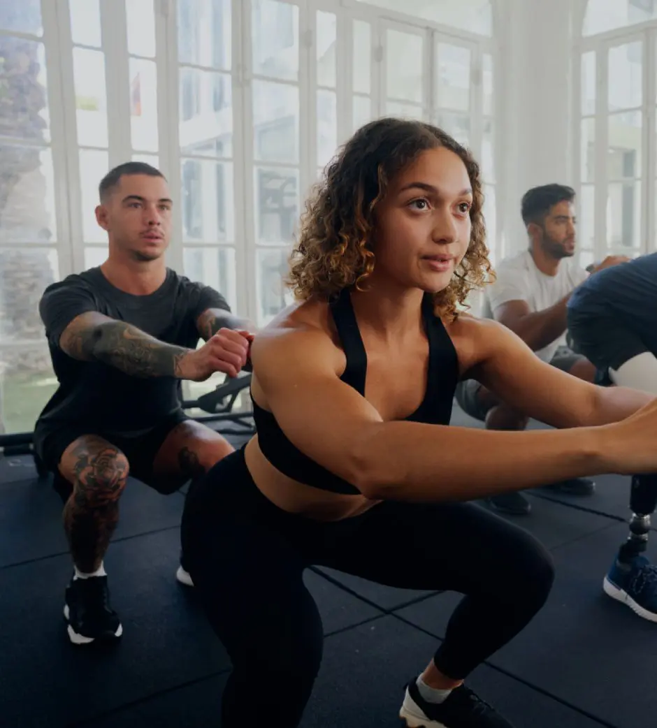 Group workout session with focused participants squatting.